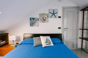 a bedroom with a blue bed with three pictures on the wall at Terrazza d'Amare - Alassio Centro in Alassio