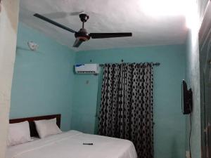 LafenwaPasasa Hotel & Event Centre的一间卧室配有吊扇和一张床