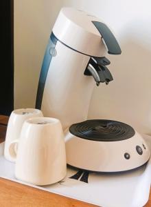 a coffee maker and cups on a table at Grande chambre cosy avec salle de bain et WC privatif in Montpellier