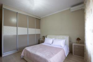 a bedroom with a white bed and a dresser at Doel's Villa in Gjirokastër