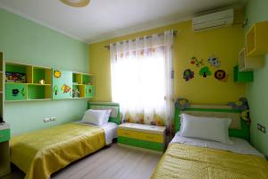a bedroom with two beds and a window at Doel's Villa in Gjirokastër