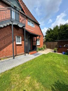 a brick house with a lawn in front of it at Naturzeit Mardorf in Neustadt am Rübenberge