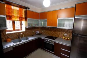 a kitchen with wooden cabinets and stainless steel appliances at Doel's Villa in Gjirokastër