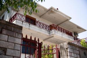 a house with a red gate and a balcony at Doel's Villa in Gjirokastër +7 photos