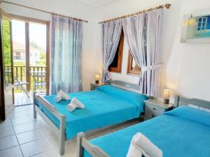 a bedroom with two beds and a balcony at Iliahtides in Kala Nera