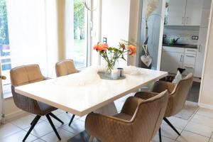a dining room with a white table and chairs at Kleiner Garten Sauna und Hallenbad kostenlos Hund willkommen in Dorum-Neufeld