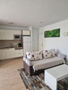 ein Wohnzimmer mit Couch und Küche in der Unterkunft HUELLA CANARIA Complejo LAS OLAS in Playa del Ingles