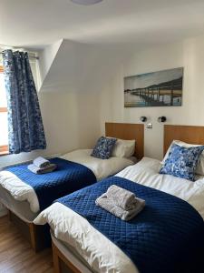 ein Schlafzimmer mit zwei Betten mit blau-weißer Bettwäsche in der Unterkunft Ulster Cottages 4 miles From Portrush Bushmills Coleraine and Ballymoney in Bushmills