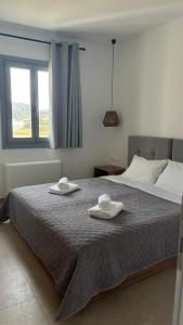 a bedroom with a bed with two towels on it at Pyrra apartments in Skiros