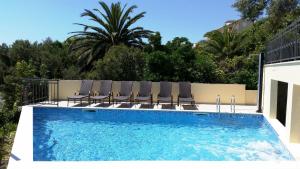 una piscina con sillas y una piscina en Apartments Kust, en Mlini