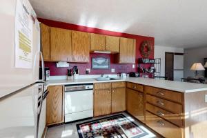 a kitchen with wooden cabinets and a white refrigerator at Buffalo Ridge 205 in Silverthorne