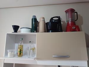 a white cabinet with bottles and other items on it at Apart próximo a Unimed, Catedral e HSA de 2 quartos com 2 AR, mini-Academia e garagem no Centro-sul in Santo Ângelo