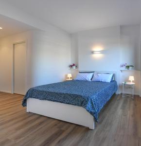 a bedroom with a bed with a blue comforter at Blu - La Casa sul Mare in Lido di Ostia