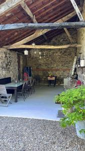 a patio with a table and chairs in a stone building at Maison Du Silence in Saint-Maurice-près-Pionsat +5 photos