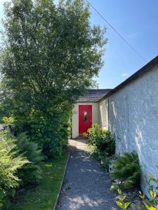 a house with a red door and a tree at Barcloy Milk House in Kirkcudbright +5 photos