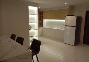 a kitchen with a refrigerator and a table and chairs at Waterfront Royal Villa in Bang Pakong