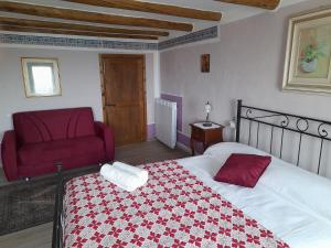 a bedroom with a bed and a red chair at B&B L'Imperfetto in Alcenago