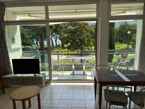 a screened in porch with a table and a television at Terrazza sul Lago in Riva del Garda