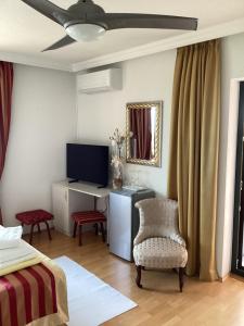 a bedroom with a bed and a desk with a television at Bed and Breakfast Villa Iris in Mošćenička Draga