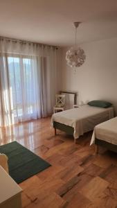 a bedroom with two beds and a chandelier at La Casa Degli Ulivi in Casarza Ligure
