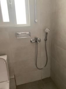 a shower with a shower head in a bathroom at Marianna's penthouse at Exarcheia square in Athens +27 photos