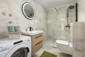 a bathroom with a washer and dryer in it at Olive Breeze in Brela +26 photos