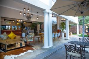 a patio with a couch and chairs and a table at Kasambabezi Lodge in Victoria Falls