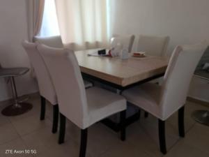a dining room table with white chairs and a table at Casa Elisa in Córdoba