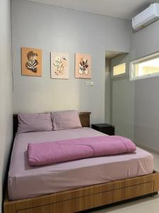 a bedroom with a large bed with pink sheets at Villa Sultana Malang in Malang +9 photos