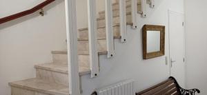 eine Treppe mit einem Spiegel und einer Holzbank in der Unterkunft Appartement privatif étage maison - 2 chambres - 5 couchages - Jardin in Chavagnes-en-Paillers + 8 Fotos