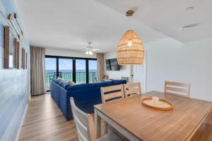 a living room with a blue couch and a table at Commodore 606 3 BR 3 BA Sleeps 12 in Panama City Beach