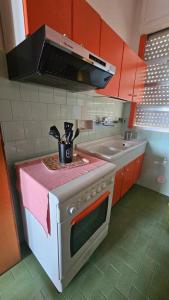 Una cocina con una estufa con encimera rosa. en Tramonto, en Porto Cesareo
