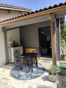 un tavolo e una sedia su un patio di Le petit nid dans les bois a Castres-Gironde