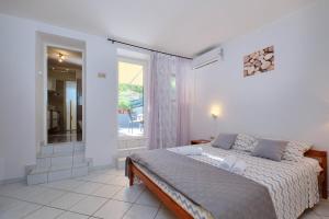 a bedroom with a large bed and a balcony at Mario in Martinšćica