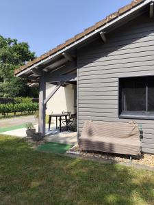 un patio con un tavolo da picnic sul lato di una casa di Le petit nid dans les bois a Castres-Gironde