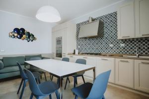 a kitchen with a table and blue chairs at Vento d'Estate B&B in Portoscuso +28 photos