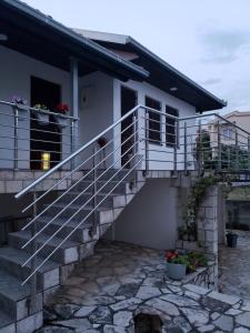 a white house with a staircase in front of it at Первая аренда уютного дома для летнего отдыха in Kravlja