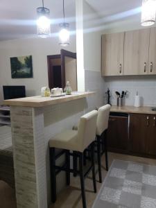 a kitchen with a bar with stools and a sink at Первая аренда уютного дома для летнего отдыха in Kravlja