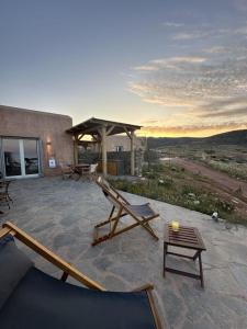 a patio with a gazebo and a table and chairs at Achinos Kimolos Studios in Kimolos