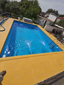 a large yellow swimming pool with blue water at Villa Verde Pet-friendly in Córdoba