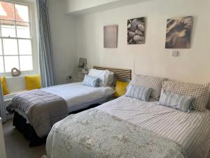 ein Schlafzimmer mit zwei Betten und einer Couch in der Unterkunft Admiralty House in Weymouth