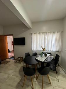 a dining room with a table and black chairs at Noel Rosa Building in Foz do Iguaçu
