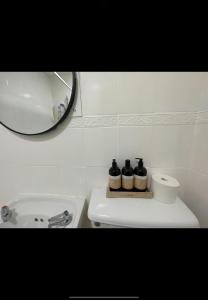 ein weißes Badezimmer mit Waschbecken und Spiegel in der Unterkunft Admiralty House in Weymouth