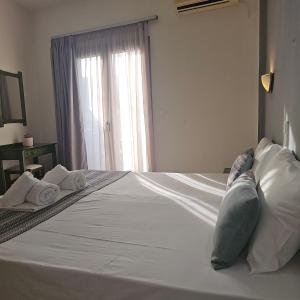 una camera da letto con un letto con due cuscini e una finestra di Joanna Apartments a Balíon