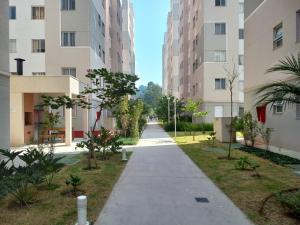 an empty sidewalk between two tall buildings at Apto novíssimo prox Alphaville e ginásio barueri in Jandira