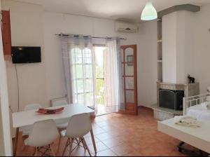 a living room with a white table and chairs at Iliahtides in Kala Nera