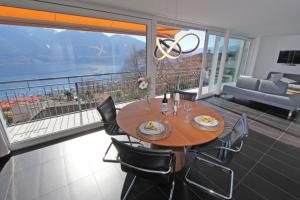 Un comedor con mesa y sillas en un balcón. en Casa Serena, 3-Zimmerwohnung-Duplex by HolAp SA, en Brione sopra Minusio