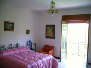 a bedroom with a bed and a chair and a window at Casa Gelferraro in Calatafimi