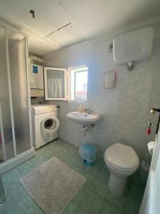 a bathroom with a toilet sink and a washing machine at Casa Senzuno - Vista mare in Follonica