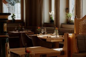 un restaurant avec des tables et des chaises en bois et des fenêtres dans l'établissement Hotel Auerhahn, à Schluchsee